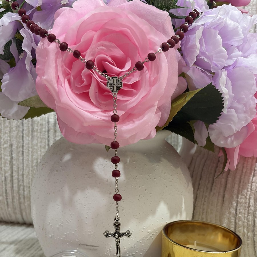 A red wooden rosary with a Jerusalem cross centerpiece